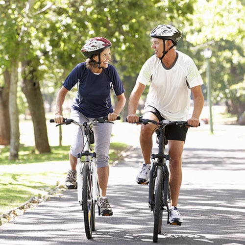 A middle-aged couple riding bicycles together