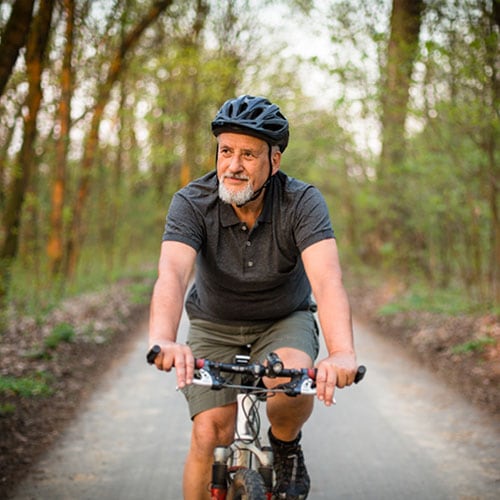 Older active man riding a bicycle on a trail