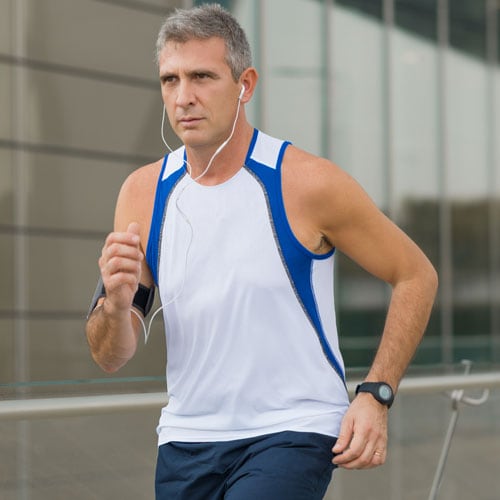 Active middle-aged man running in a city